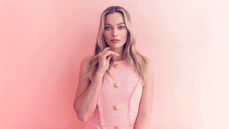 Margot Robbie at a LuckyChap Entertainment event smiling with confidence
