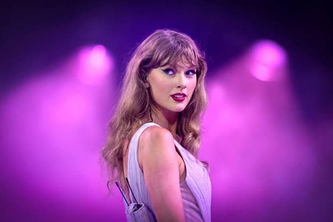 Taylor Swift performing on the Eras Tour stage in a stadium